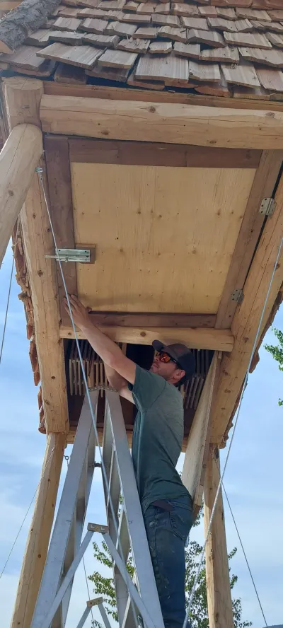 Liam Kinders standing underneath the freshly-installed bat condo at Penticton Channel Parkway