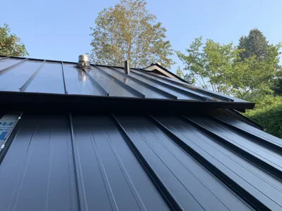 Side view of metal roof installation on lakefront cabin, Okanagan