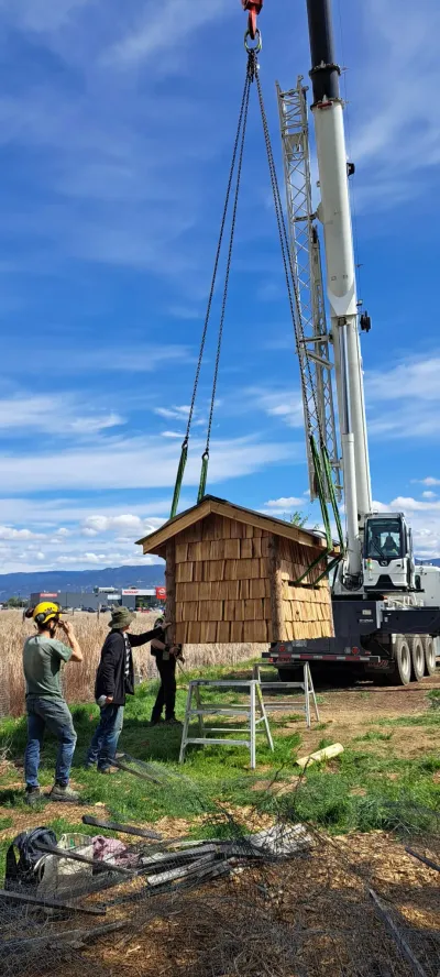 Crane lowering the bat condo onto the piling foundation at Penticton Channel Parkway